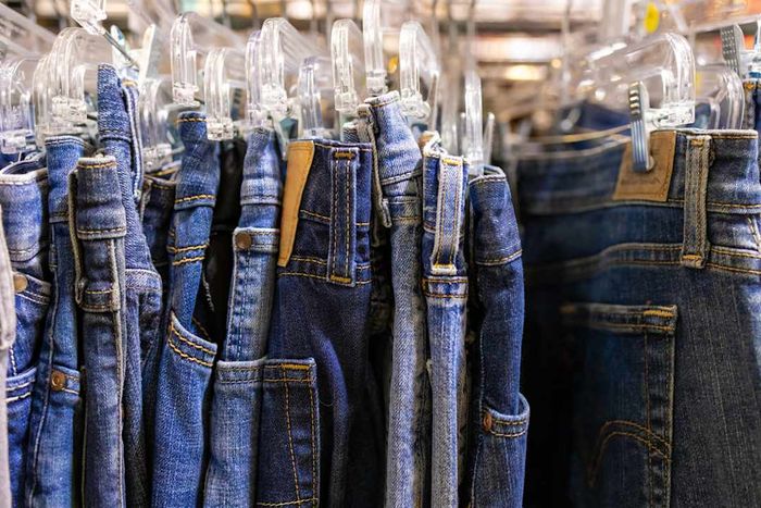 Rack of vintage denim blue jeans at antique flea market