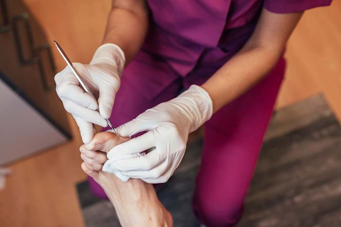 A chiropodist treating a patient's feet.