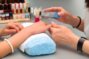 A woman receiving a manicure for her fingernails.
