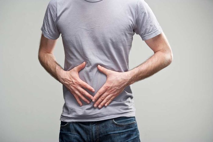 A person clutching their stomach with their torso visible