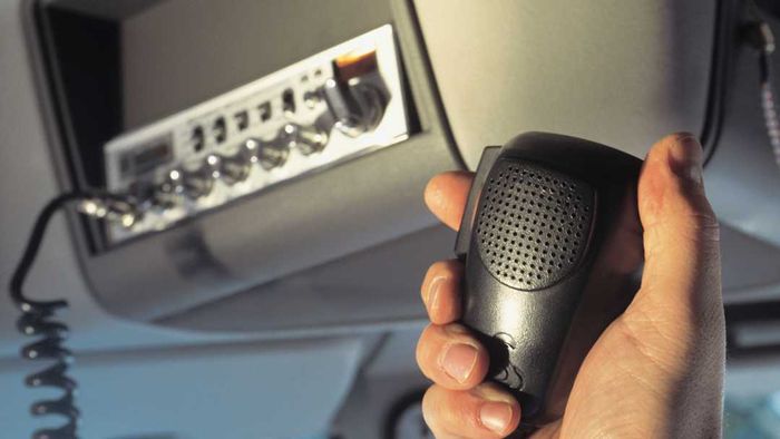 A hand gripping a CB radio