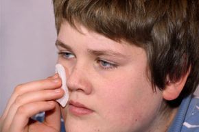 A teenager cleansing their face.