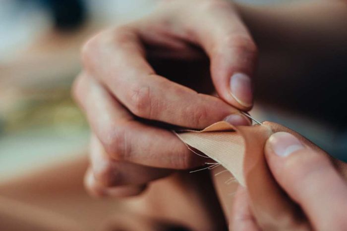 A dressmaker’s hands skillfully stitching fabric