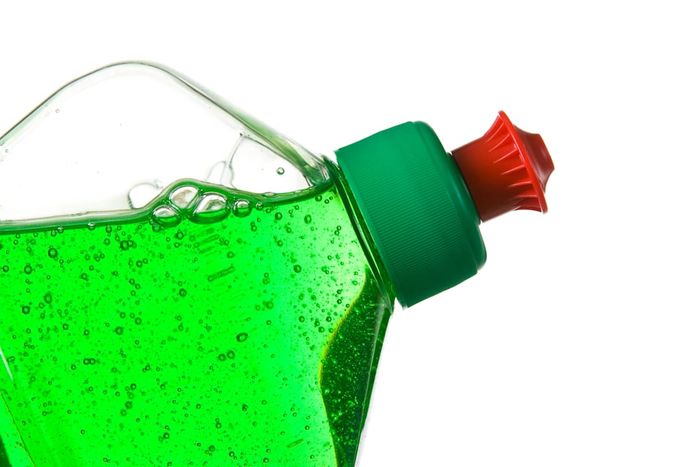 A close-up view of a green bottle of dishwashing liquid.