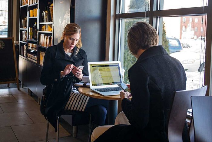 Two people working at a table in a coffee shop