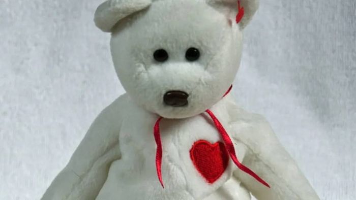 A white Valentino the Bear Beanie Baby featuring a red heart on its chest, set against a white background.