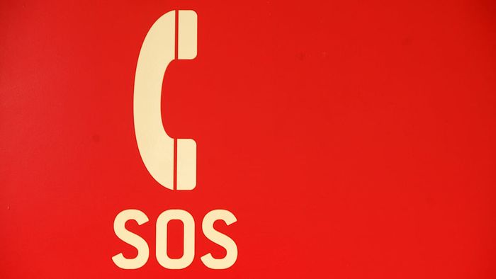 The symbol of a telephone receiver with the letters SOS underneath