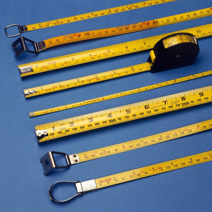 A collection of yellow tape measures arranged on a blue background