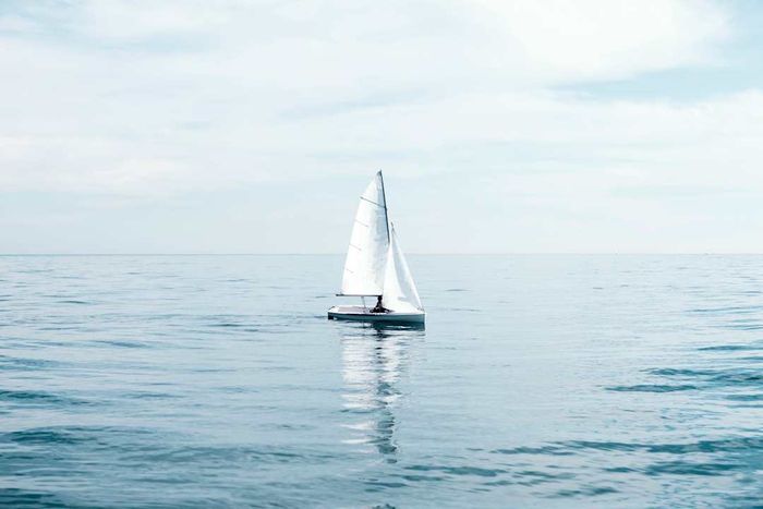 A sailboat navigating the ocean under overcast skies