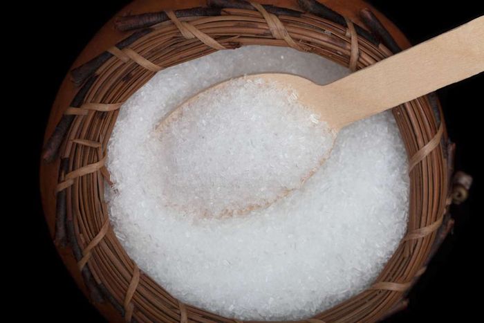 A wicker bowl filled with Epsom salts and a spoon