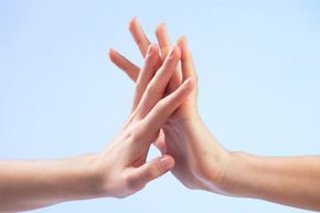 Two hands softly meeting each other.