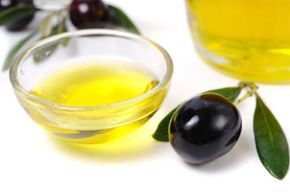 Olive oil, black olives, olive branches, and a bottle of olive oil.