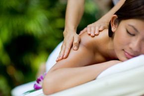 A woman enjoying a massage at a serene tropical spa