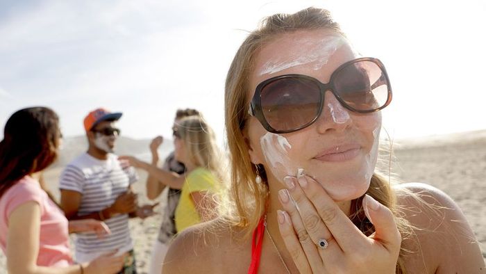 Individual applying sunblock