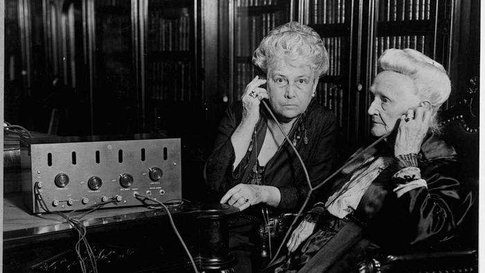 Elderly women tuning in to the radio