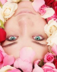 woman sitting in a bathtub surrounded by rose petals
