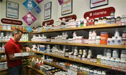 A man filling shelves with vitamins