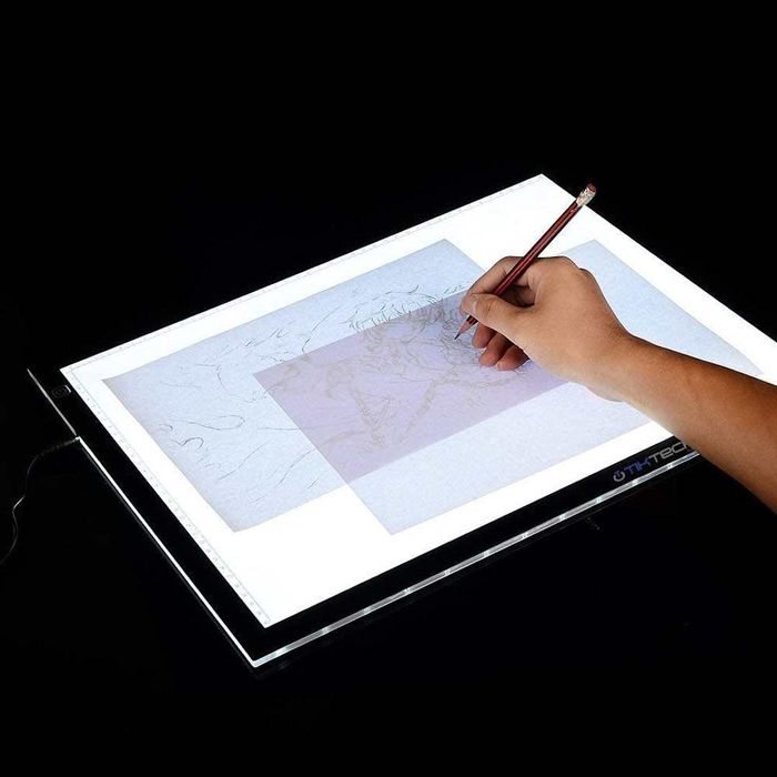 Artist working on a light box tracer.