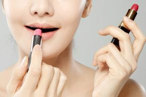 A woman experimenting with two types of lip products