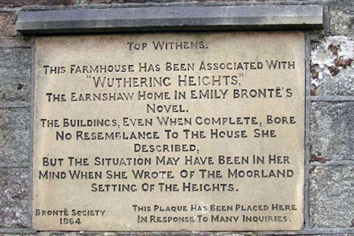 A stone wall plaque partially reads, 