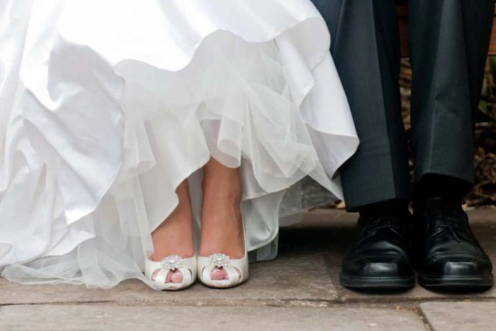 Image of a bride and groom’s feet and shoes