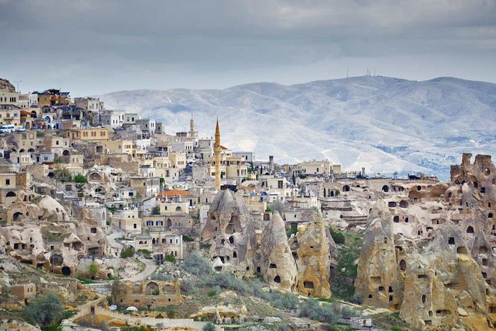 Göreme town featuring a mosque and homes carved into rock formations, Cappadocia region, Turkey