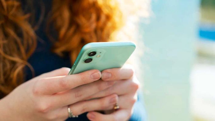 A woman is shown using a mobile phone