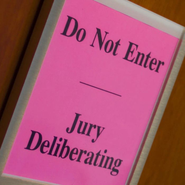 A sign indicating jury deliberation is displayed