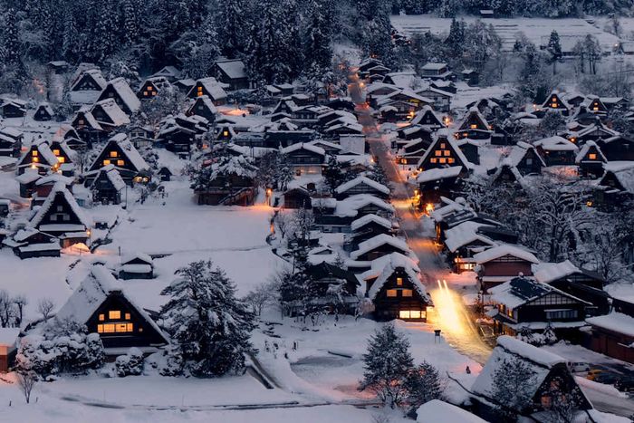 An aerial view of Shirakawa-go in winter, blanketed in snow as dusk falls