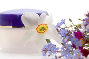 an empty cosmetic cream container adorned with flowers