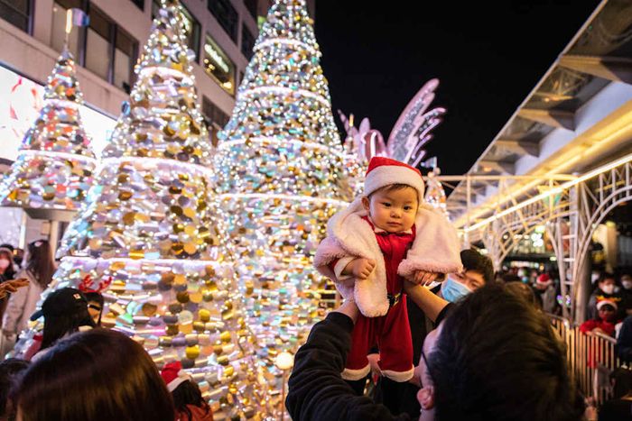 A father lifts his infant son at a shopping center in Hong...