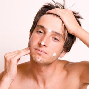 A man applying moisturizer to his face.