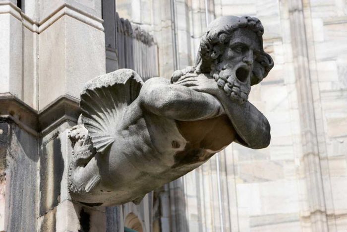 A human-shaped stone gargoyle at the Duomo di Milano in Milan, Italy.