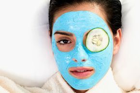 A woman receiving a facial treatment with a mask covering her face.