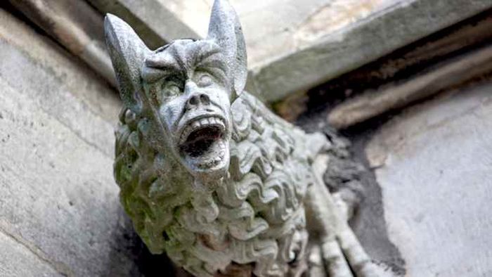 A spooky downspout shaped like a gargoyle, located at the Church of Saint Severin in Paris, France.