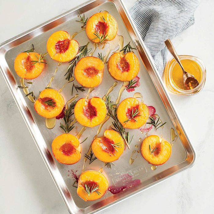 Nordic Ware Aluminum Baker's Half Sheets, Set of 2, adorned with fresh peaches.