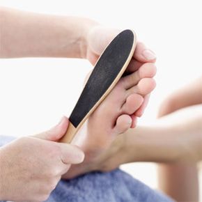 Individual smoothing the bottom of their foot.
