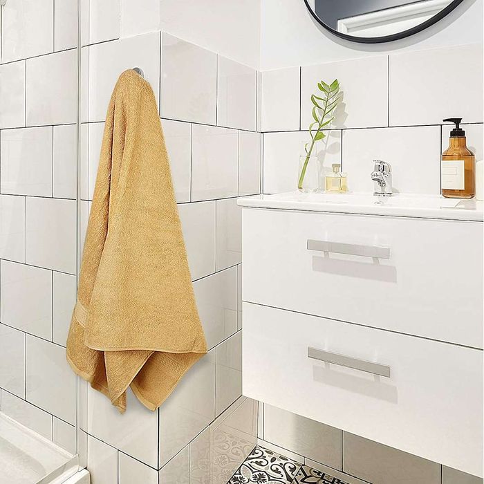 A beige Utopia Towel elegantly draped over a hook.