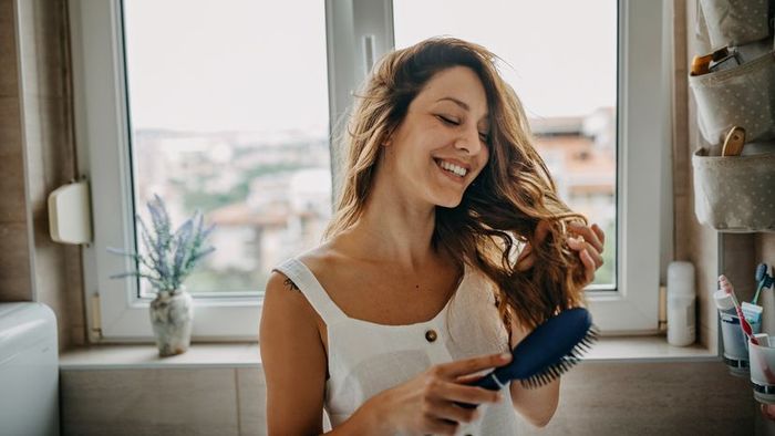 A young woman brushing through her hair