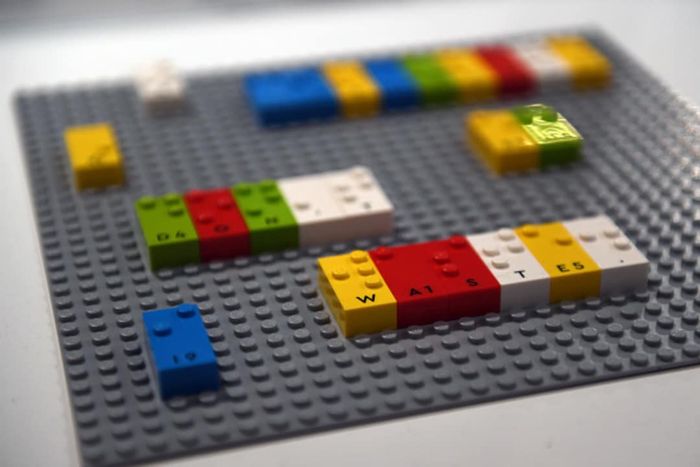 An image of vibrant braille LEGO bricks placed on a gray LEGO base.