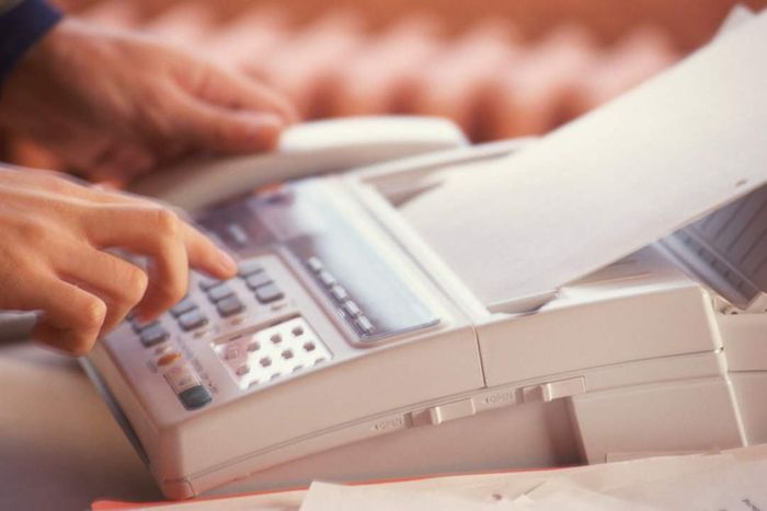 A person operating a fax machine