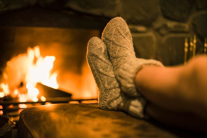 Sock-clad feet warming by a fire