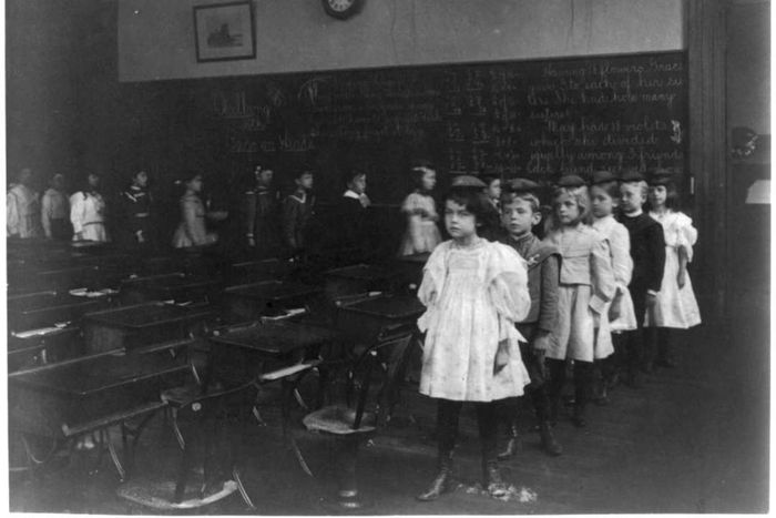 Children marching in a line around the classroom