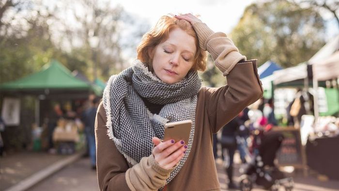A red-haired woman in London appears exhausted while shopping in a market