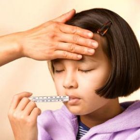 a young girl feeling unwell, holding a thermometer in her mouth
