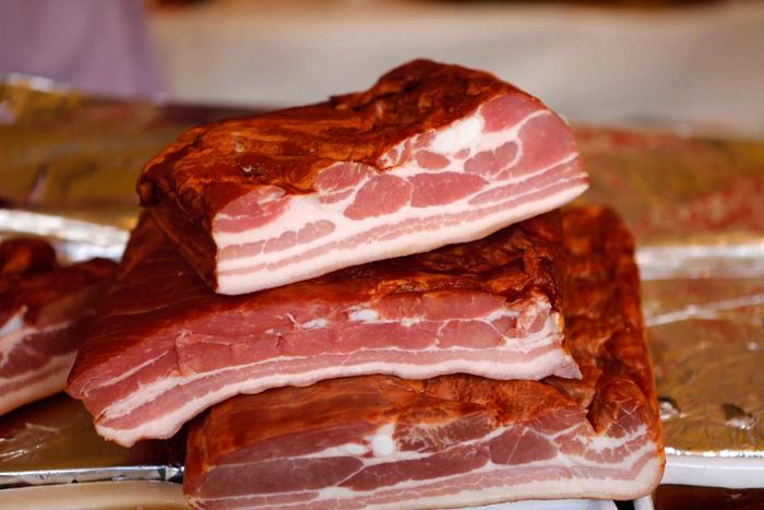 Slabs of bacon laid out on a table.