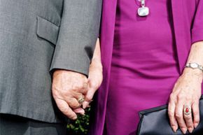 elderly couple clasping hands