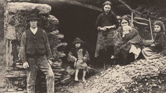 An Irish family standing amidst the remains of their home in Killarney.