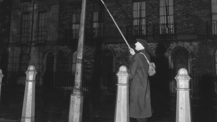 John Jennings, London's oldest lamplighter, extinguishing a lamp in Clerkenwell at 4:45 am.