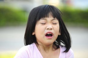 A young girl on the verge of sneezing